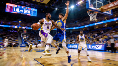 NBA篮球比赛洛杉矶湖人队与金州勇士队的直播画面,球员正在突破上篮